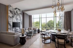 Courtyard by Marriott Shenzhen Northwest في باوان: غرفة معيشة مع طاولة وكراسي وأريكة