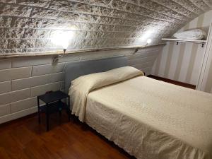 a room with two beds in a room with a brick wall at GILU' in Adelfia