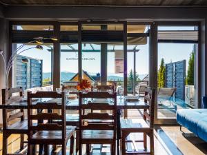 comedor con mesa, sillas y ventanas en Słoneczny Chełm - Dla aktywnych i wypoczywających - Sauna, Balia&Jacuzzi Prive, en Myślenice