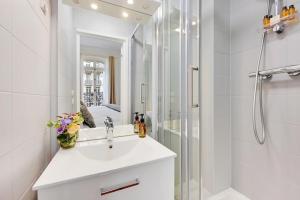 ein weißes Bad mit einem Waschbecken und einer Dusche in der Unterkunft Eiffel Tower 5 bedrooms 10 guests with 2 Carpark in Paris