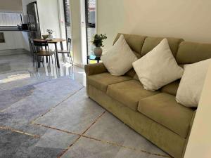 a brown couch in a living room with a table at Granny Guest house Sydney Blue Mount in Kingswood