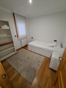 um quarto branco com uma cama e um tapete em Calle Areal muy céntrico em Vigo