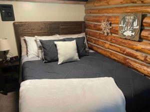 a bed in a room with a log wall at Little Cabin in the Woods. in Post Falls