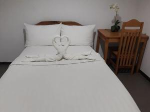 1 cama con 2 toallas en forma de corazón en Amor's Place en Puerto Princesa