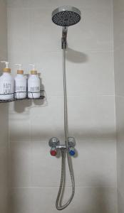 a shower in a bathroom with four bottles of soap at APARTAMENTO TURISTICO GUADIANA LOFT EXPERIENCE Dalia in Badajoz