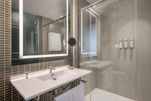 a white bathroom with a sink and a shower at AC Hotel Recoletos by Marriott in Madrid