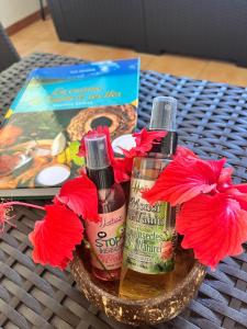 Papara的住宿－Tahiti - Kea Lodge，桌子上放了两瓶肥皂和鲜花