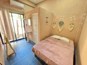 a bedroom with a bed and a bathroom with a window at Casa Lol-cab Hostal in Valladolid