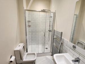 een badkamer met een douche, een toilet en een wastafel bij Leopold House Liverpool in Liverpool