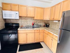 a kitchen with wooden cabinets and a black refrigerator at Greater Grand Crossing/Hyde Park in Chicago