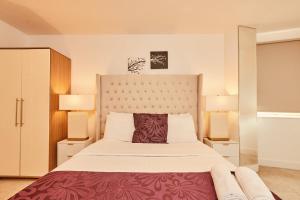 - une chambre avec un grand lit et deux lampes dans l'établissement Modern Deluxe Leeds Dock Apartment Free Parking, à Leeds