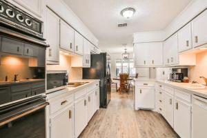 a kitchen with white cabinets and a black refrigerator at Hot Tub, Privacy, sleeps 10 & TONS of Space! in Lubbock