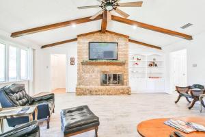 a living room with a brick fireplace and a tv at Hot Tub, Privacy, sleeps 10 & TONS of Space! in Lubbock