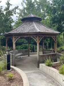 a wooden gazebo with a bench in a park at Luxury Condo with city skyline views - Mins to YYZ in Toronto