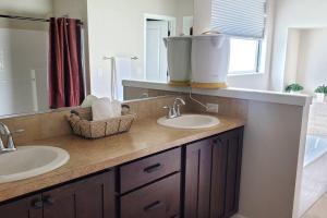 baño con 2 lavabos y espejo grande en Family Fun! Gorgeous North Idaho Home w/Tesla Charge : Prairie Inn en Post Falls