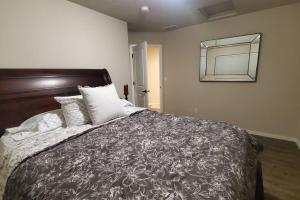 1 dormitorio con cama y espejo en la pared en Family Fun! Gorgeous North Idaho Home w/Tesla Charge : Prairie Inn en Post Falls