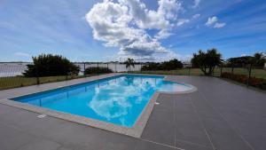 a large swimming pool with a blue at Coucher de soleil sur le lagon 4 à 5p avec piscine in Marigot