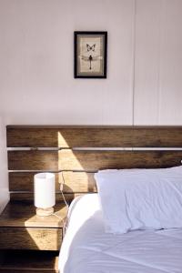 a bedroom with a bed with a wooden headboard at Lodge Sol De Cáhuil in Pichilemu