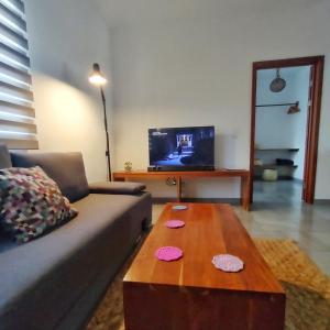 Blue Mahahual في ماهاهوال: غرفة معيشة مع أريكة وطاولة قهوة خشبية