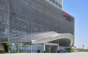 a building with a car parked in front of it at Yancheng Marriott Hotel in Yancheng