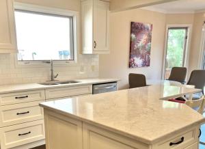 cocina con armarios blancos y encimera en Crescent Heights Majesty en Calgary