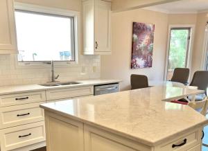 a kitchen with white cabinets and a counter top at Crescent Heights Majesty in Calgary