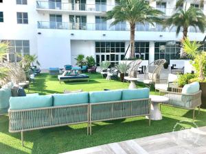 un patio con divani e tavoli blu e un edificio di Luxury 3-bedroom with breathtaking view - Daily resort fee and parking not included a Hollywood