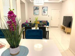 una sala de estar con una mesa con flores púrpuras. en NEW! Condo on Shary, en Mission