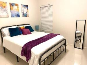 1 dormitorio con 1 cama grande con almohadas azules y moradas en NEW! Condo on Shary, en Mission