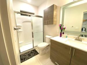 y baño con ducha, aseo y lavamanos. en NEW! Condo on Shary en Mission