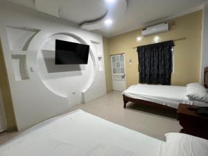 Hotel SMIR في Huaquillas: غرفة نوم بسرير وتلفزيون بشاشة مسطحة
