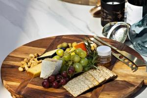 eine Holzplatte aus Lebensmitteln mit Traubenkäse und anderen Lebensmitteln in der Unterkunft Limerick Home in Queenstown