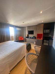 um quarto de hotel com uma cama, uma mesa e cadeiras em Lindo Flat Part Grand Mercure Varanda aconchegante em Brasília