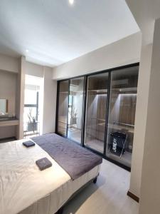 ein Schlafzimmer mit einem großen Bett und einem großen Fenster in der Unterkunft Kuching 3rd Mile Cozy Apartment in Kuching