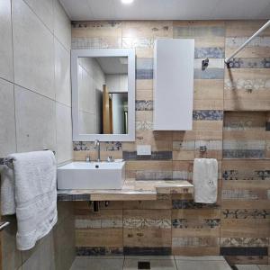 a bathroom with a sink and a mirror at Hotel Miceli in Bragado