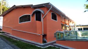 Chácara da Tia Elaine في ريبيراو بيريس: مبنى احمر على جانبه نافذه