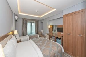 イスタンブールにあるFloransa City Hotelのベッドとデスクが備わるホテルルームです。