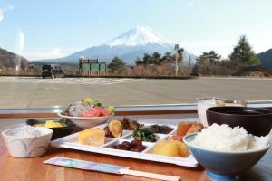 a plate of food on a table with a mountain at Shoji Mount Hotel in Fujikawaguchiko