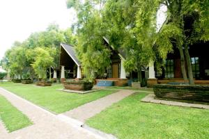 ein Haus mit Rasen und Bäumen davor in der Unterkunft Avasta Resort and Spa in Anuradhapura