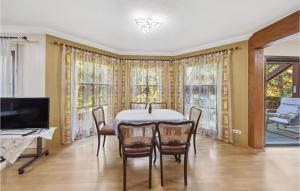 uma sala de jantar com uma mesa e cadeiras e uma televisão em Pet Friendly Home In Falkenberg With Sauna em Herzberg