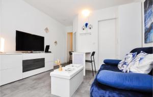 uma sala de estar com um sofá azul e uma televisão em Nice Apartment In Beausoleil With Wifi em Beausoleil