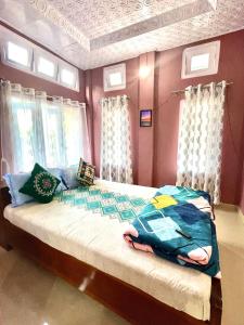 sypialnia z dużym łóżkiem z fioletowymi ścianami i oknami w obiekcie Namdang Homestay w mieście Sibsāgar