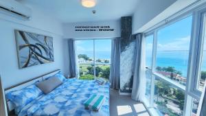 a room with a bed with a view of the ocean at La Mirada Residences in Mactan