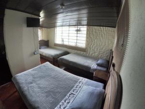 a small room with two beds and a window at Libélula Cabaña- Alojamiento rural in Duitama