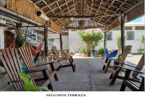 een groep stoelen en hangmatten onder een paviljoen bij Hostel Tadeo San Juan del Sur in San Juan del Sur