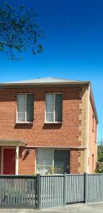 ceglany dom z białym płotem przed nim w obiekcie Ballarat CBD Accommodation 2 Bd Townhouse Talbot Terrace w mieście Ballarat