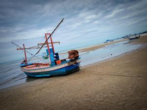 a boat sitting on the shore of a beach at The Casa Blanca Room condo in Hua Hin