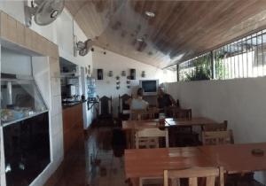 dos personas sentadas en una mesa en un restaurante en Hostel Tadeo San Juan del Sur, en San Juan del Sur