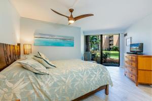 a bedroom with a bed and a ceiling fan at Kauhale Makai 122 in Kihei