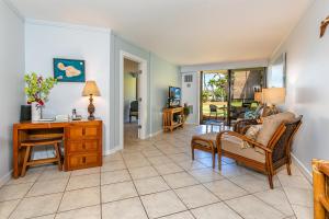 a living room with a desk and chairs at Kauhale Makai 122 in Kihei